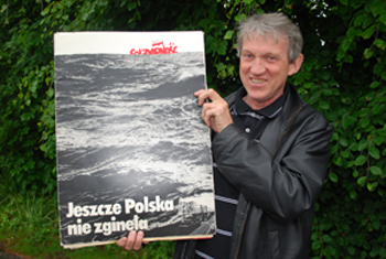 Kazimierz Rochowicz viser fram en av plakatene fra Solidaritet i sin samling. (Foto: OAM/Maihaugen)